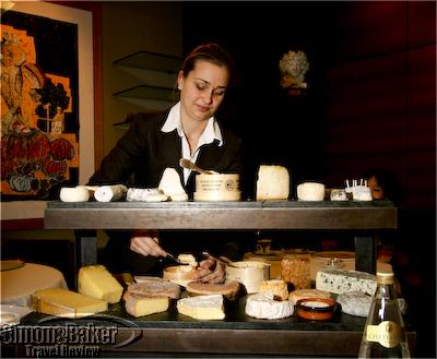 A young server brings the cheese trolley at Guy Savoy